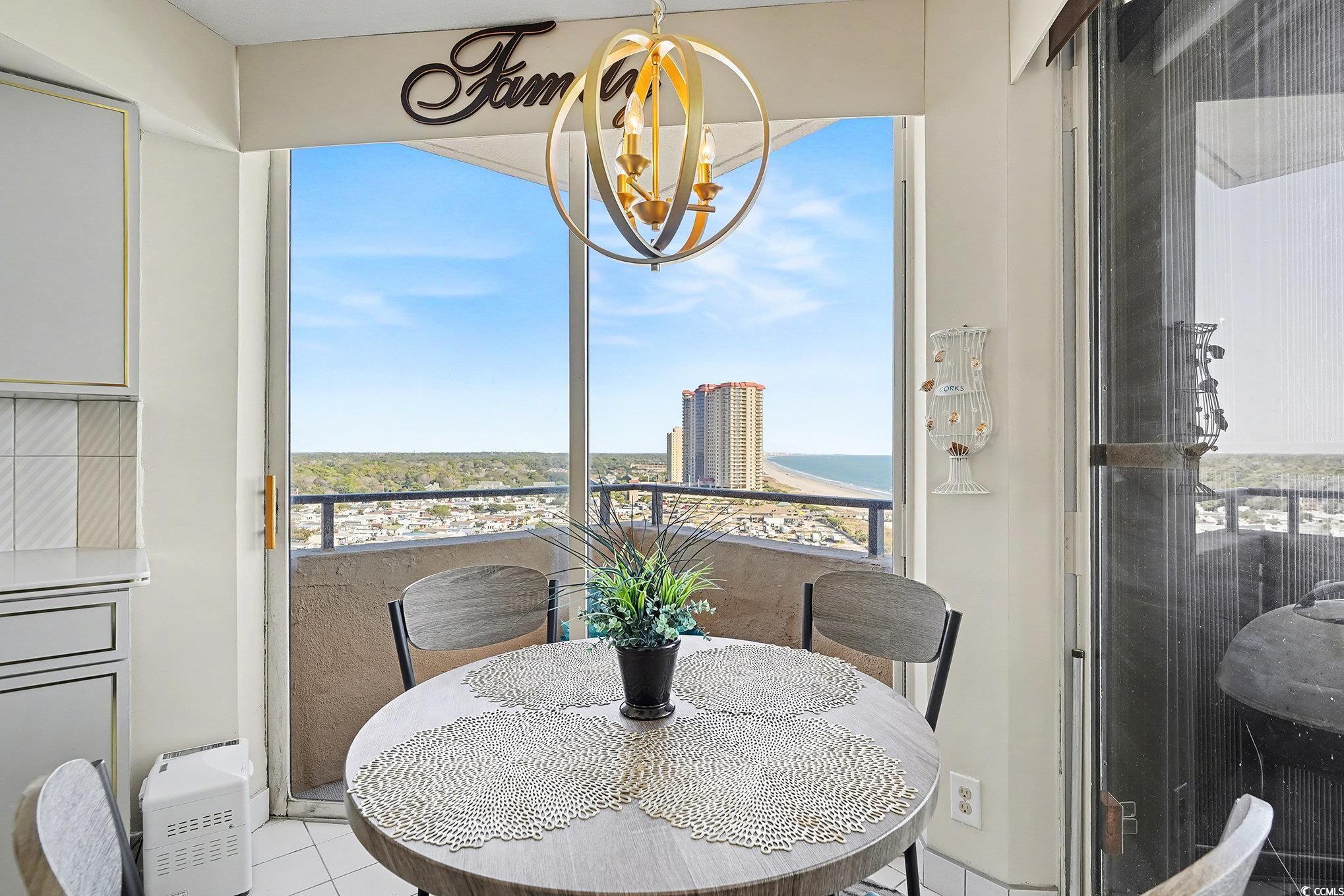 9650 Shore Drive, Unit 1507 Myrtle Beach, SC 29572 - Photo 8 of 39 Tiled dining space featuring a chandelier and plenty of natural light