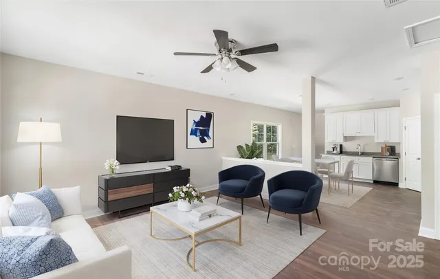 a living room with furniture a ceiling fan and a window