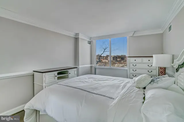 a bedroom with a bed and a large mirror