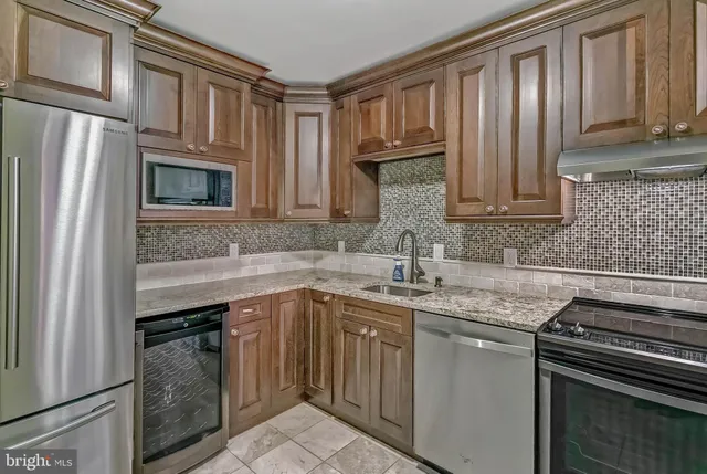 a kitchen with stainless steel appliances granite countertop a stove microwave and refrigerator