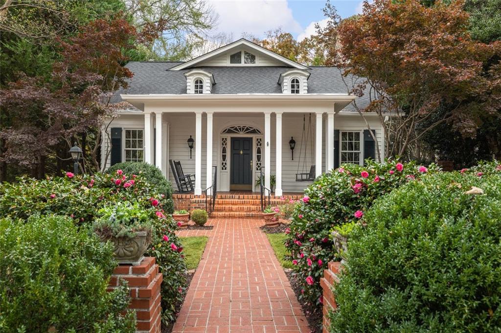 front view of a house with a small yard and potted plants