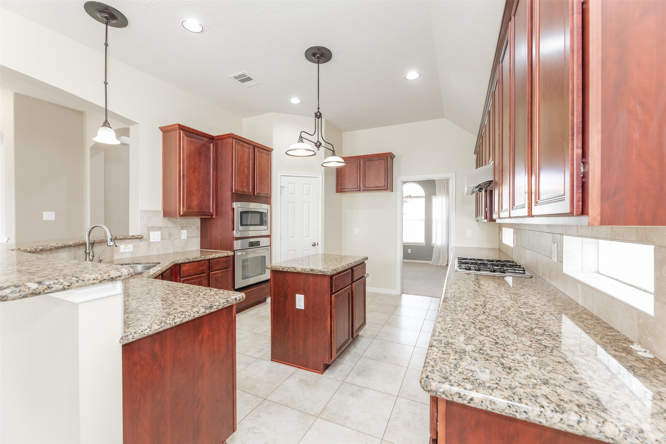 25919 Pebble Terrane Lane Katy, TX 77494 - Photo 13 of 28 a large kitchen with stainless steel appliances granite countertop a sink and a stove