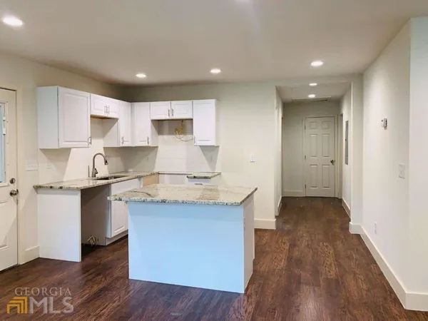 a kitchen with a sink and wooden floor