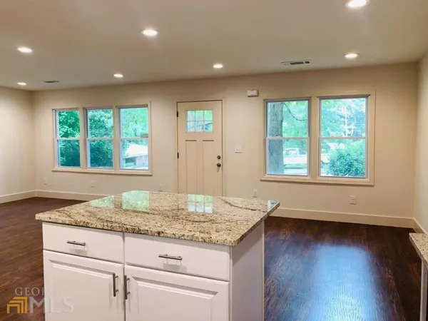 a kitchen with granite countertop wooden floor and a window