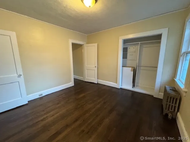 an empty room with wooden floor and a window