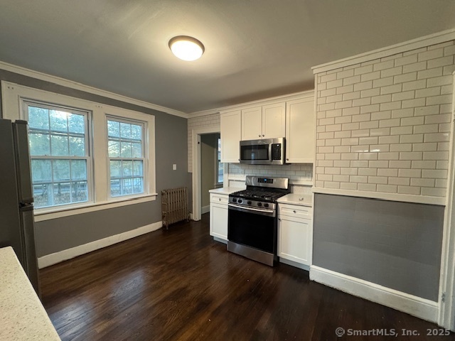 463 Highland Avenue Stratford, CT 06614 - Photo 3 of 14 a kitchen with stainless steel appliances a stove a sink a refrigerator white cabinets and wooden floor