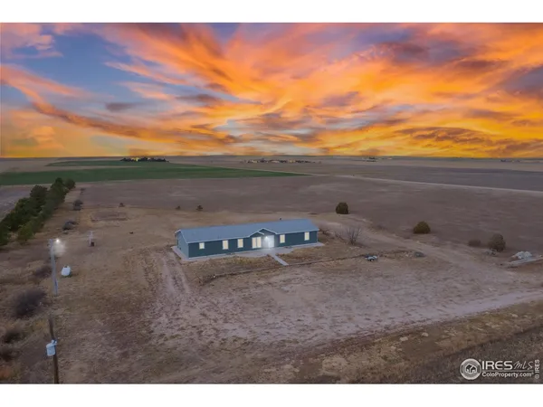 a view of a dry yard with wooden fence