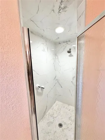 a bathroom with a glass shower door and a sink