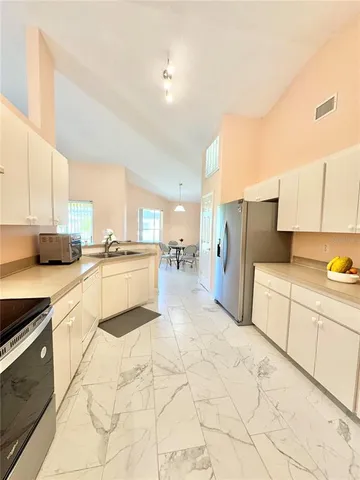 a large white kitchen with cabinets