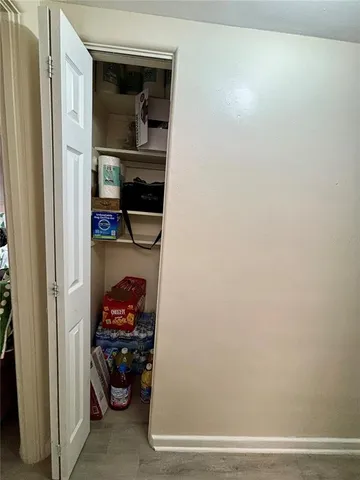 a view of a hallway with closet and a utility room