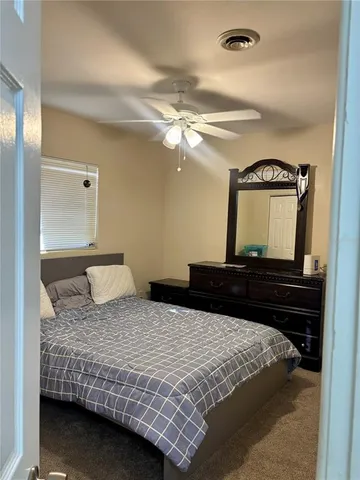 a bedroom with a bed and a lamp on dresser