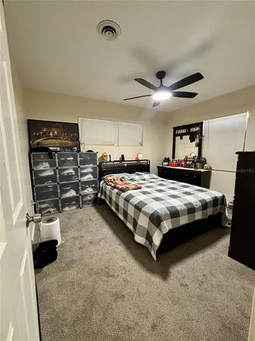 a bedroom with bed and ceiling fan