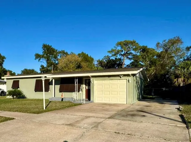 a view of a house with a backyard and a garage