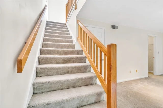 a view of staircase with wooden floor and white walls