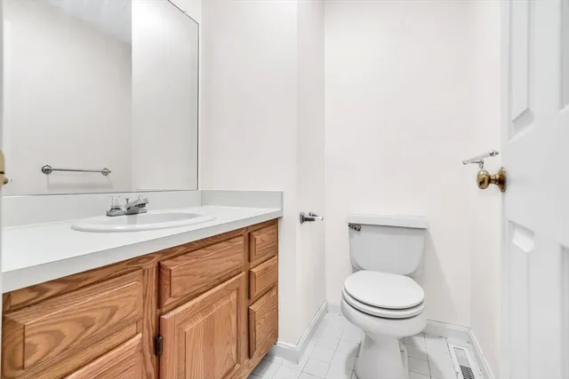 a bathroom with a toilet a sink a mirror and vanity