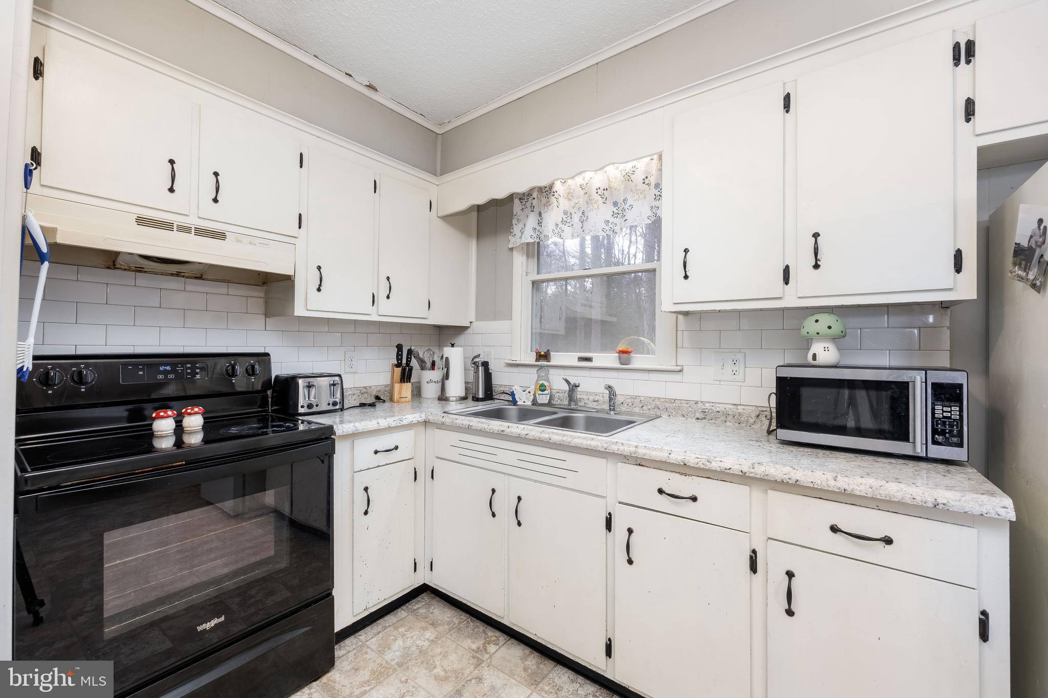 6870 Zion Church Road Salisbury, MD 21804 - Photo 13 of 39 a kitchen with granite countertop white cabinets and a stove