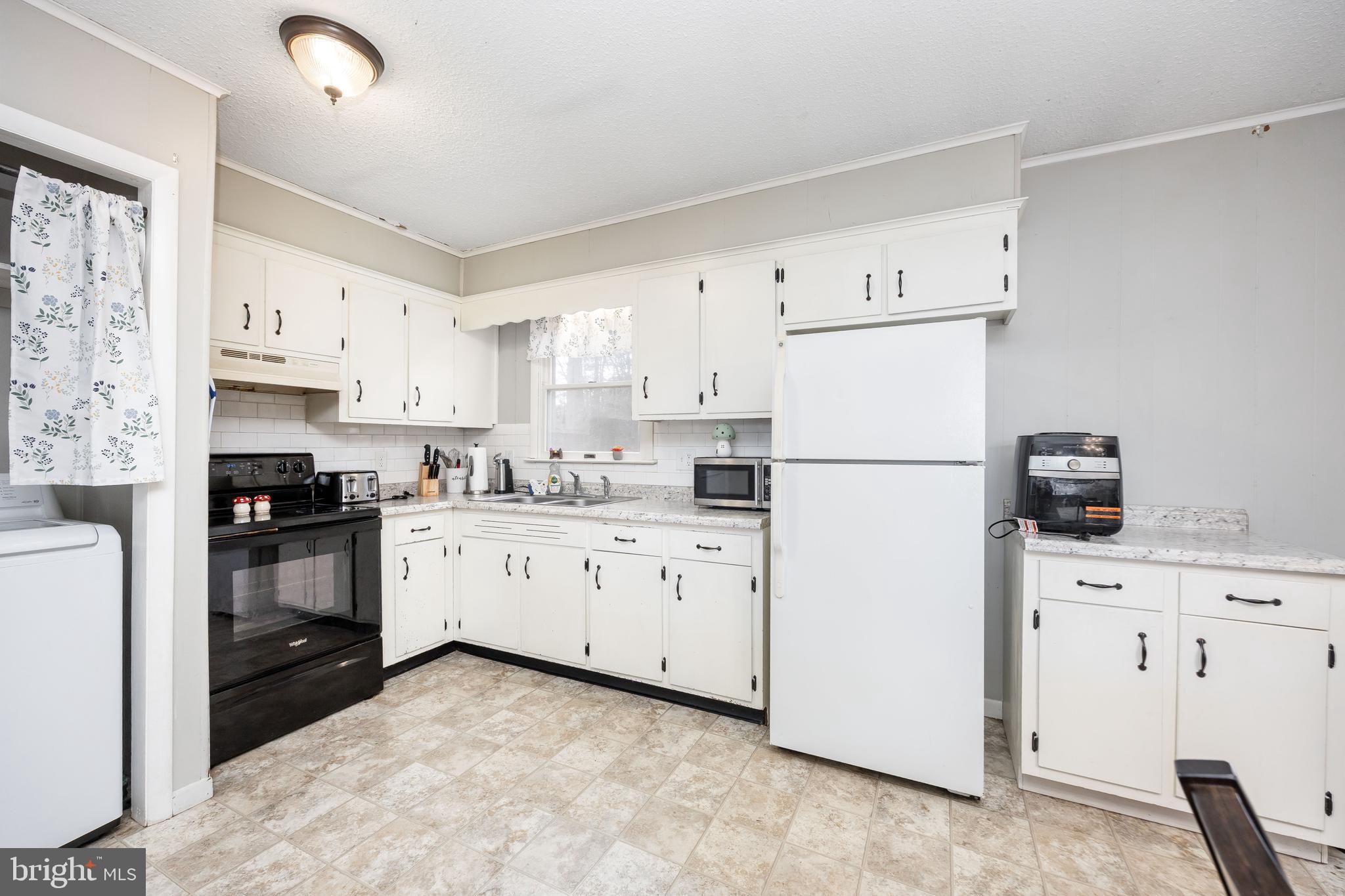 6870 Zion Church Road Salisbury, MD 21804 - Photo 14 of 39 a kitchen with cabinets appliances a sink and a window