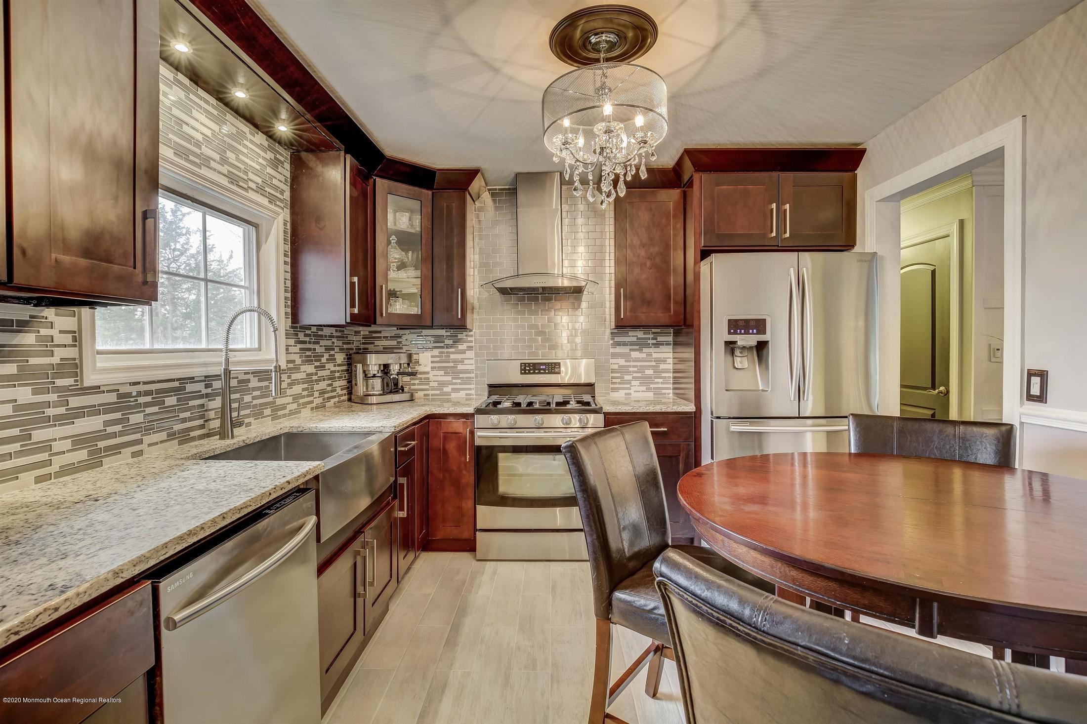 4 Wickatunk Road Manalapan, NJ 07726 - Photo 12 of 23 a kitchen with stainless steel appliances granite countertop a stove a refrigerator a sink a stove and island