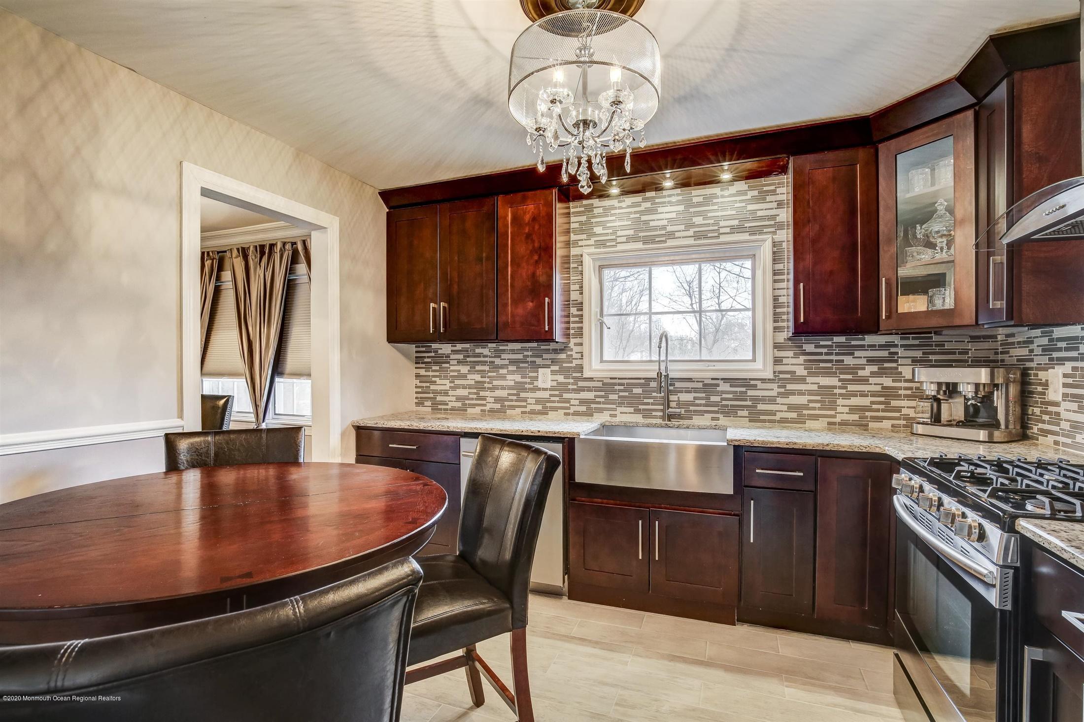 4 Wickatunk Road Manalapan, NJ 07726 - Photo 13 of 23 a kitchen with stainless steel appliances granite countertop a sink a stove a dining table and chairs