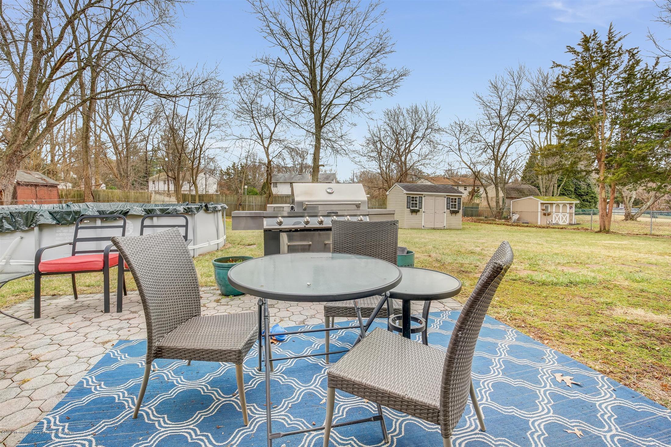 4 Wickatunk Road Manalapan, NJ 07726 - Photo 22 of 23 a backyard of a house with table and chairs