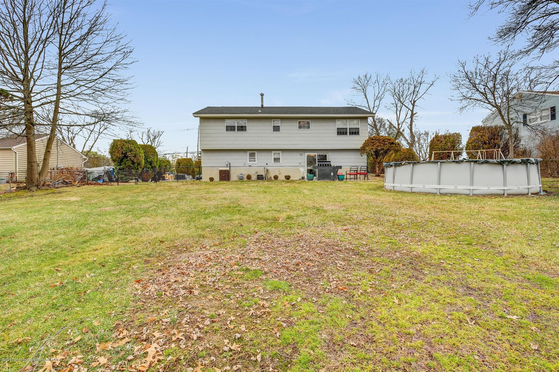 4 Wickatunk Road Manalapan, NJ 07726 - Photo 23 of 23 a view of a big house with a large tree and a yard in front of it