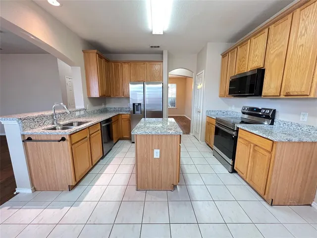 a kitchen with stainless steel appliances granite countertop a stove a sink dishwasher and a microwave