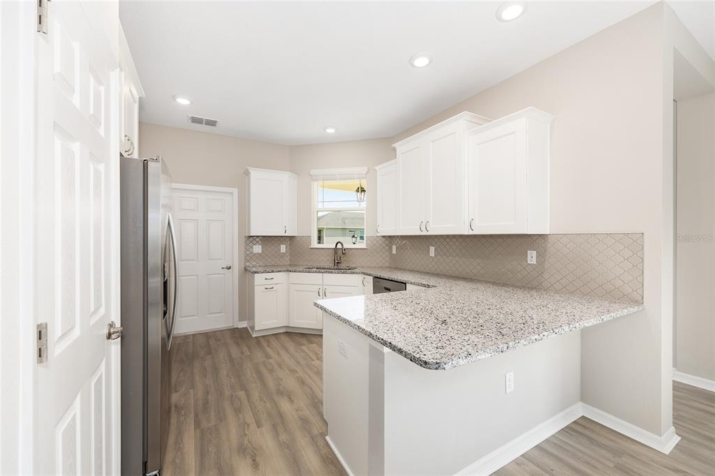 7288 Southwest 89th Avenue Ocala, FL 34481 - Photo 17 of 34 a kitchen with a sink a stove a refrigerator and white cabinets