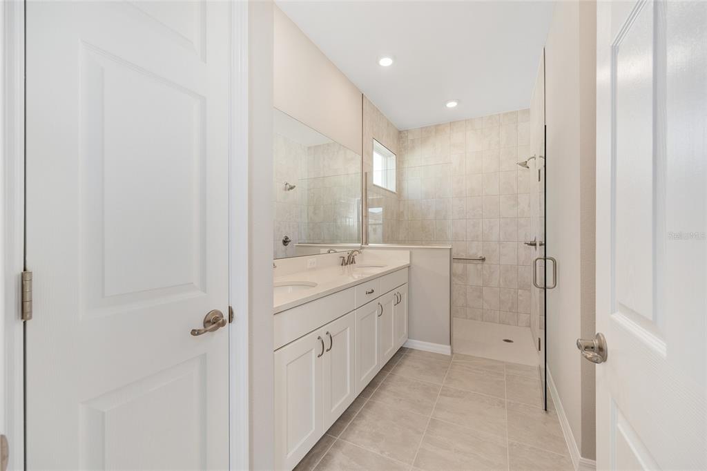 7288 Southwest 89th Avenue Ocala, FL 34481 - Photo 21 of 34 a spacious bathroom with a double vanity sink a mirror and a shower