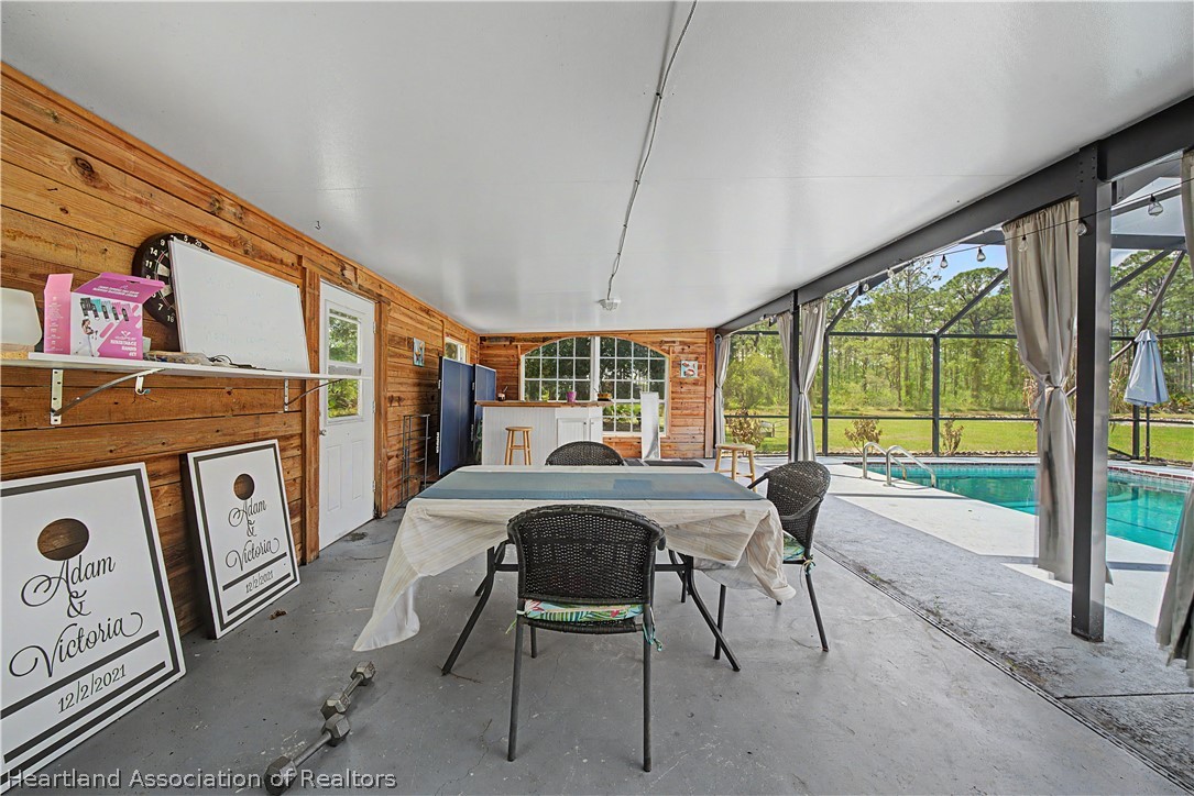 5731 Wolf Lake Road Sebring, FL 33875 - Photo 15 of 45 a view of a dining room with furniture large windows and wooden floor