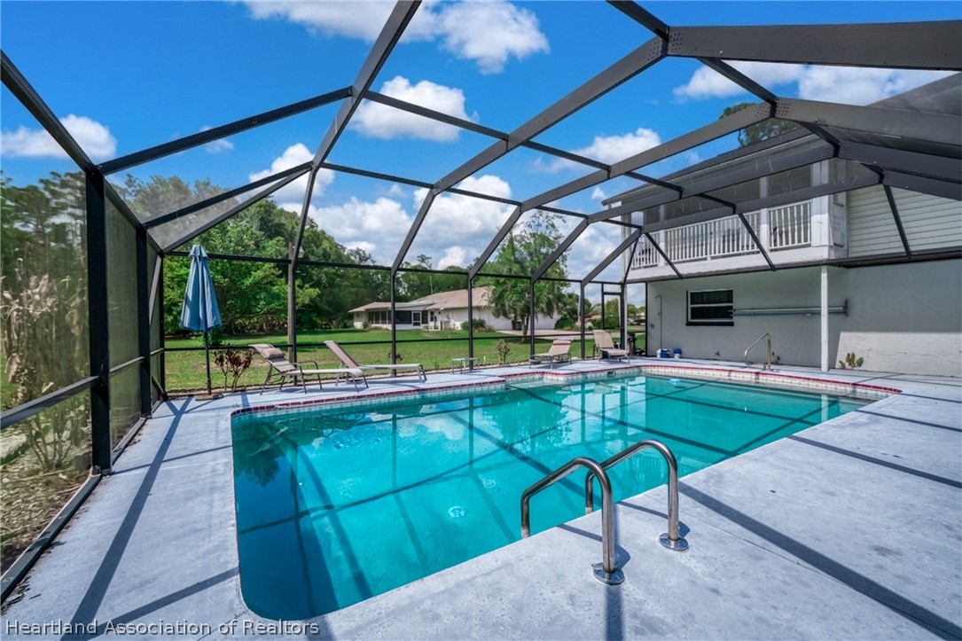 5731 Wolf Lake Road Sebring, FL 33875 - Photo 17 of 45 a view of a swimming pool with a patio