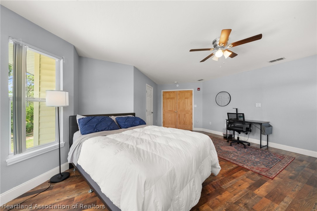 5731 Wolf Lake Road Sebring, FL 33875 - Photo 23 of 45 a bedroom with a bed a table and windows