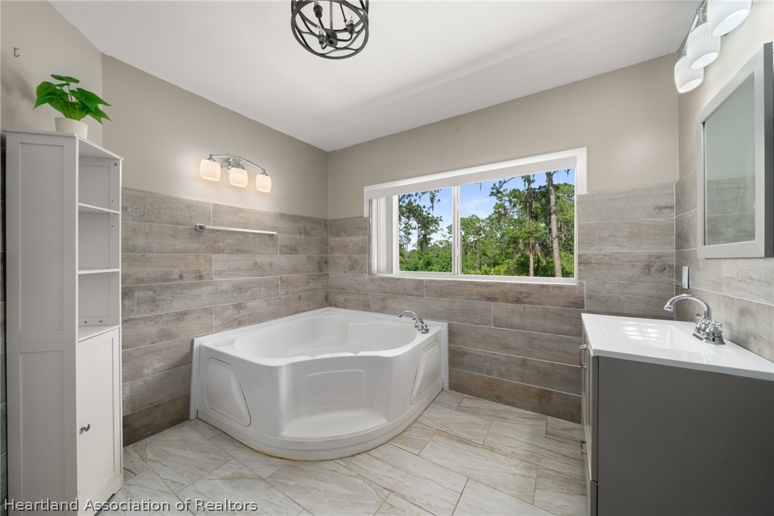 5731 Wolf Lake Road Sebring, FL 33875 - Photo 27 of 45 a bathroom with a bathtub and window