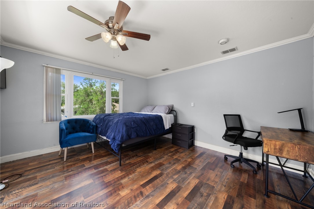 5731 Wolf Lake Road Sebring, FL 33875 - Photo 29 of 45 a bedroom with a bed window and a desk