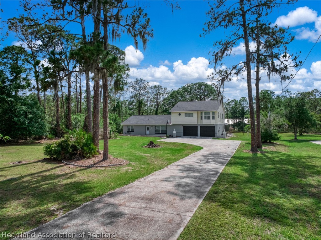 5731 Wolf Lake Road Sebring, FL 33875 - Photo 41 of 45 a front view of a house with garden