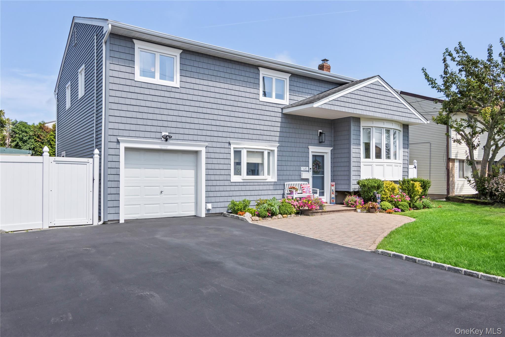 3483 Steven Road Baldwin, NY 11510 - Photo 28 of 30 a front view of a house with a yard and a garage