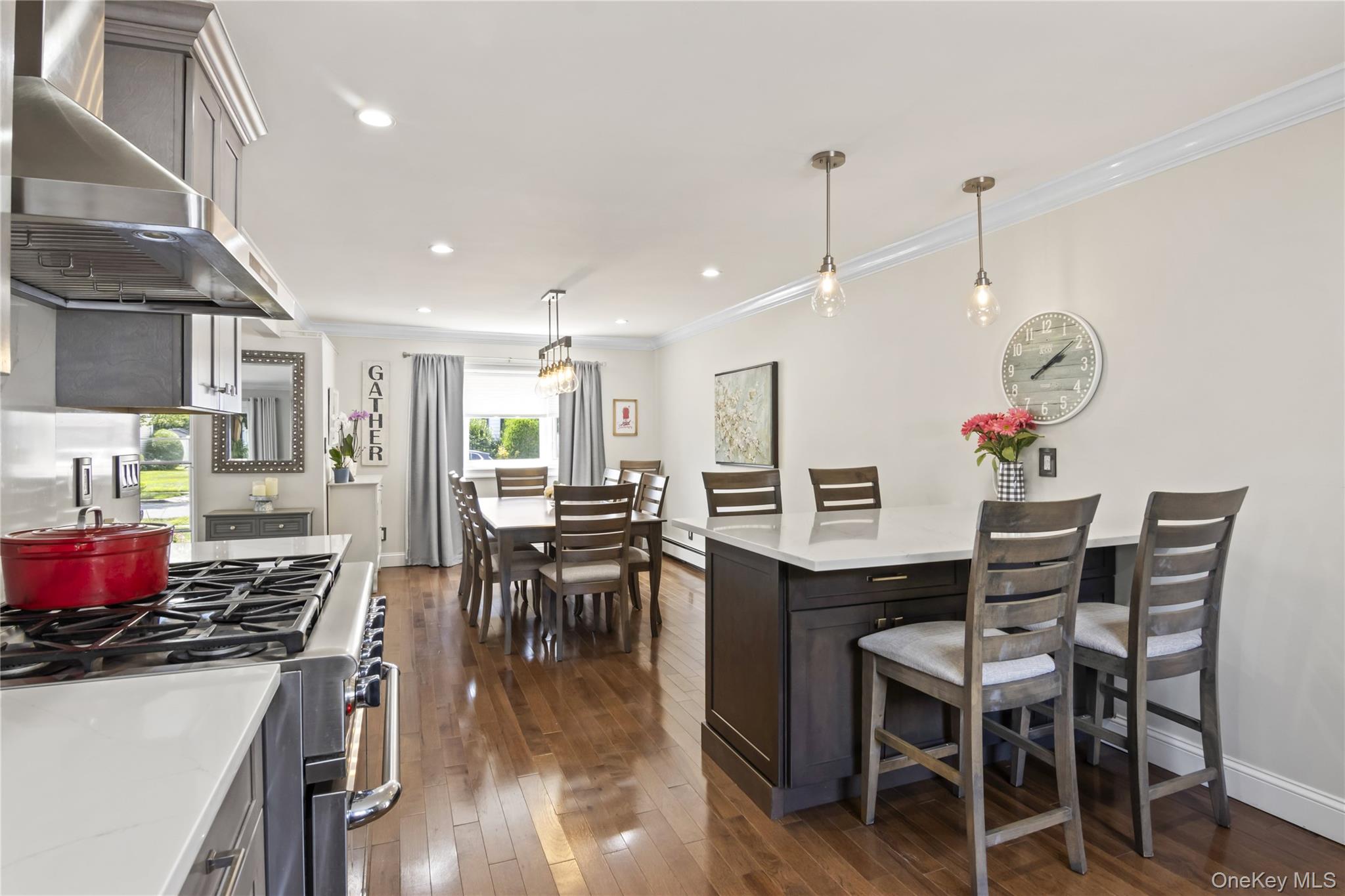 3483 Steven Road Baldwin, NY 11510 - Photo 3 of 30 a kitchen with stainless steel appliances a dining table chairs stove and white cabinets