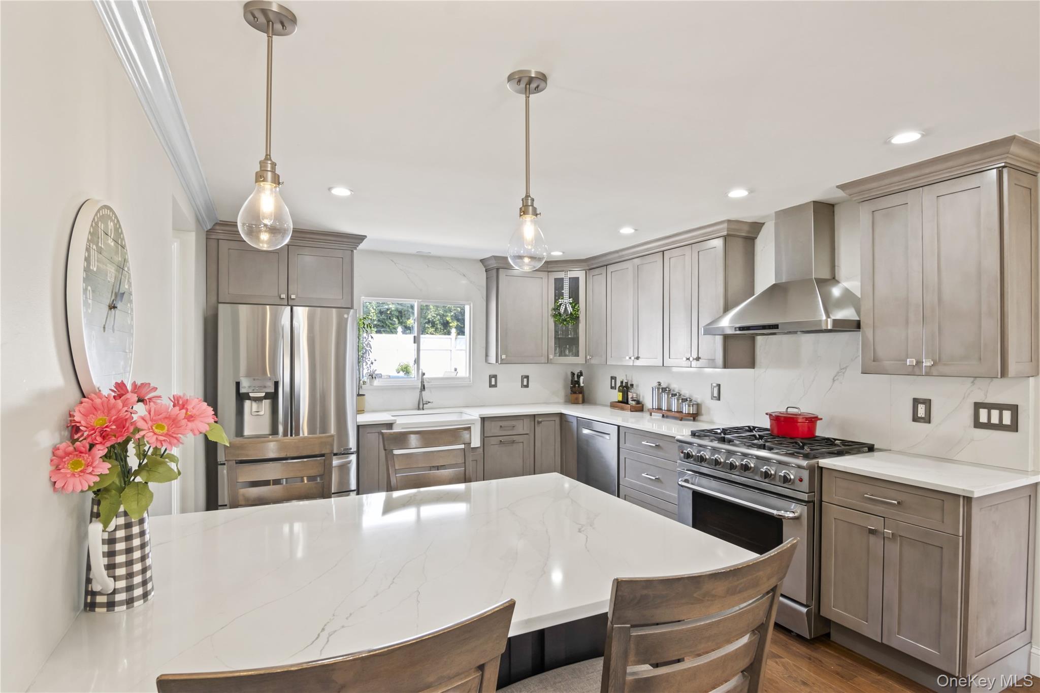 3483 Steven Road Baldwin, NY 11510 - Photo 4 of 30 a kitchen with stainless steel appliances a stove a sink dishwasher a dining table and chairs with wooden floor