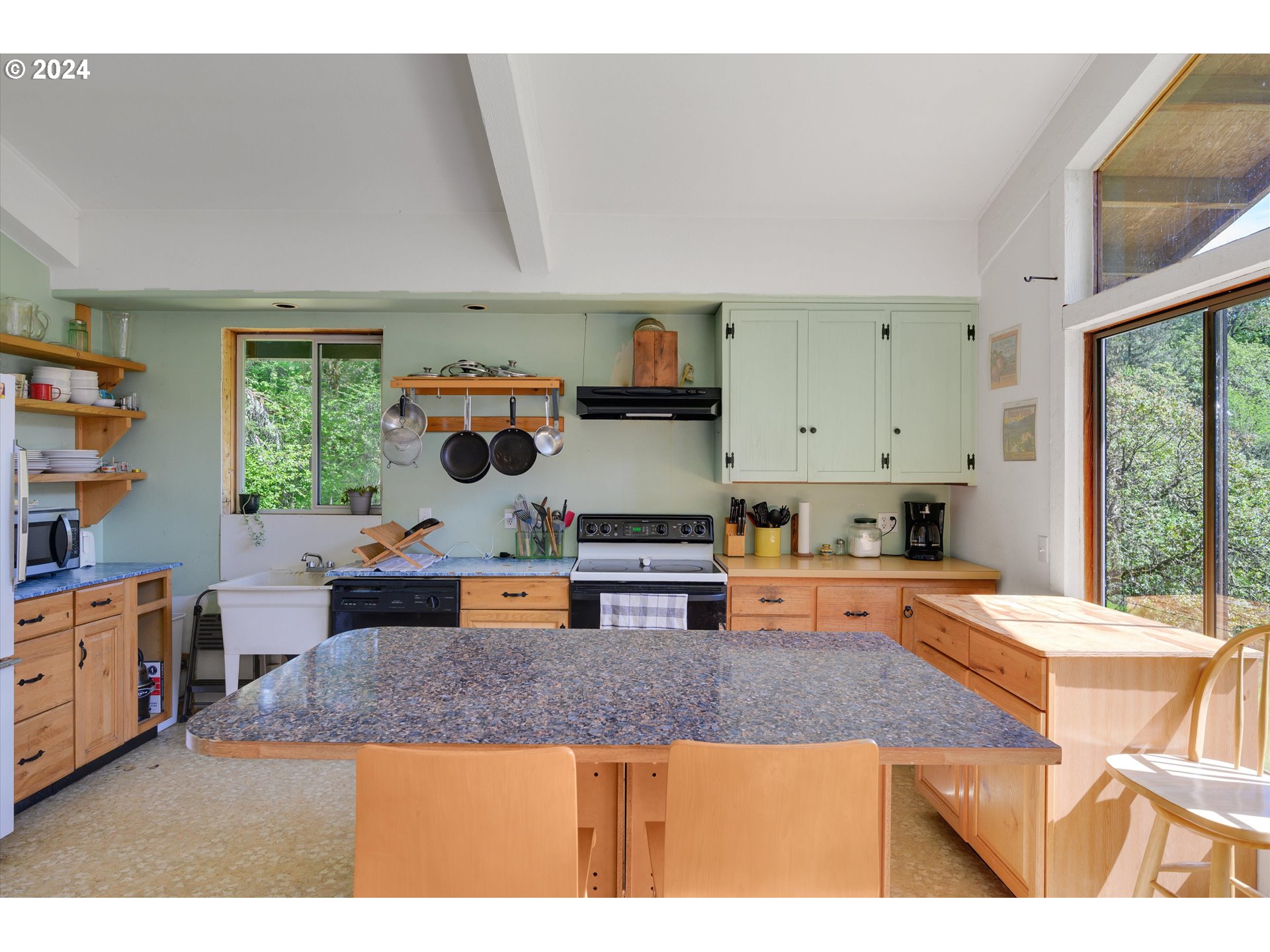 14885 Ferns Corner Road Dallas, OR 97338 - Photo 8 of 47 a kitchen with kitchen island granite countertop a stove and large window