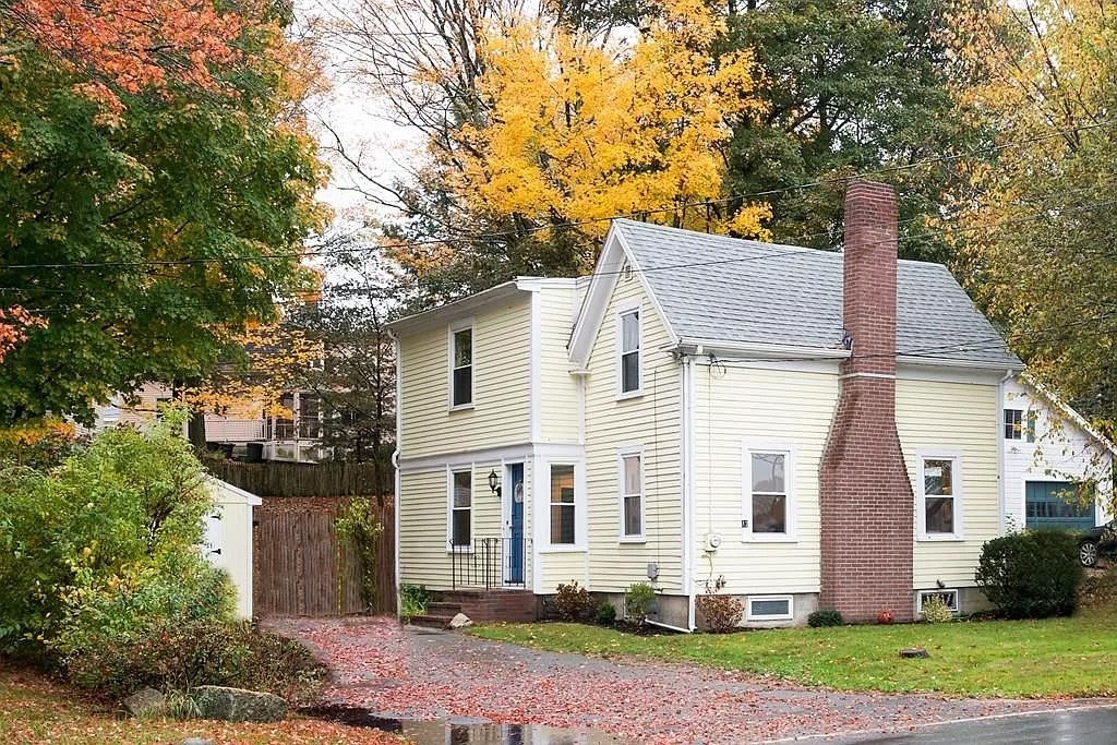 a view of a white house with a yard and plants