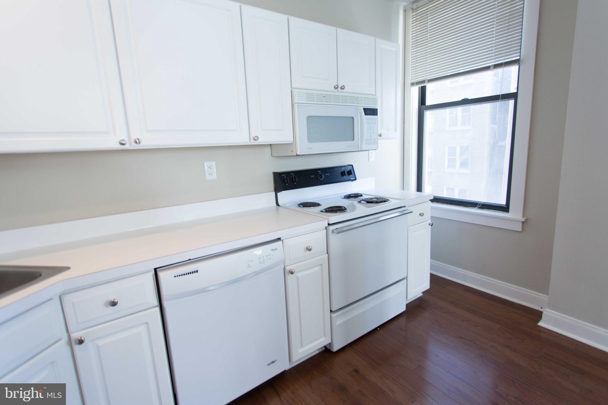 1411-5 Walnut Street, Unit 908 Philadelphia, PA 19102 - Photo 15 of 31 a kitchen with white cabinets and white appliances
