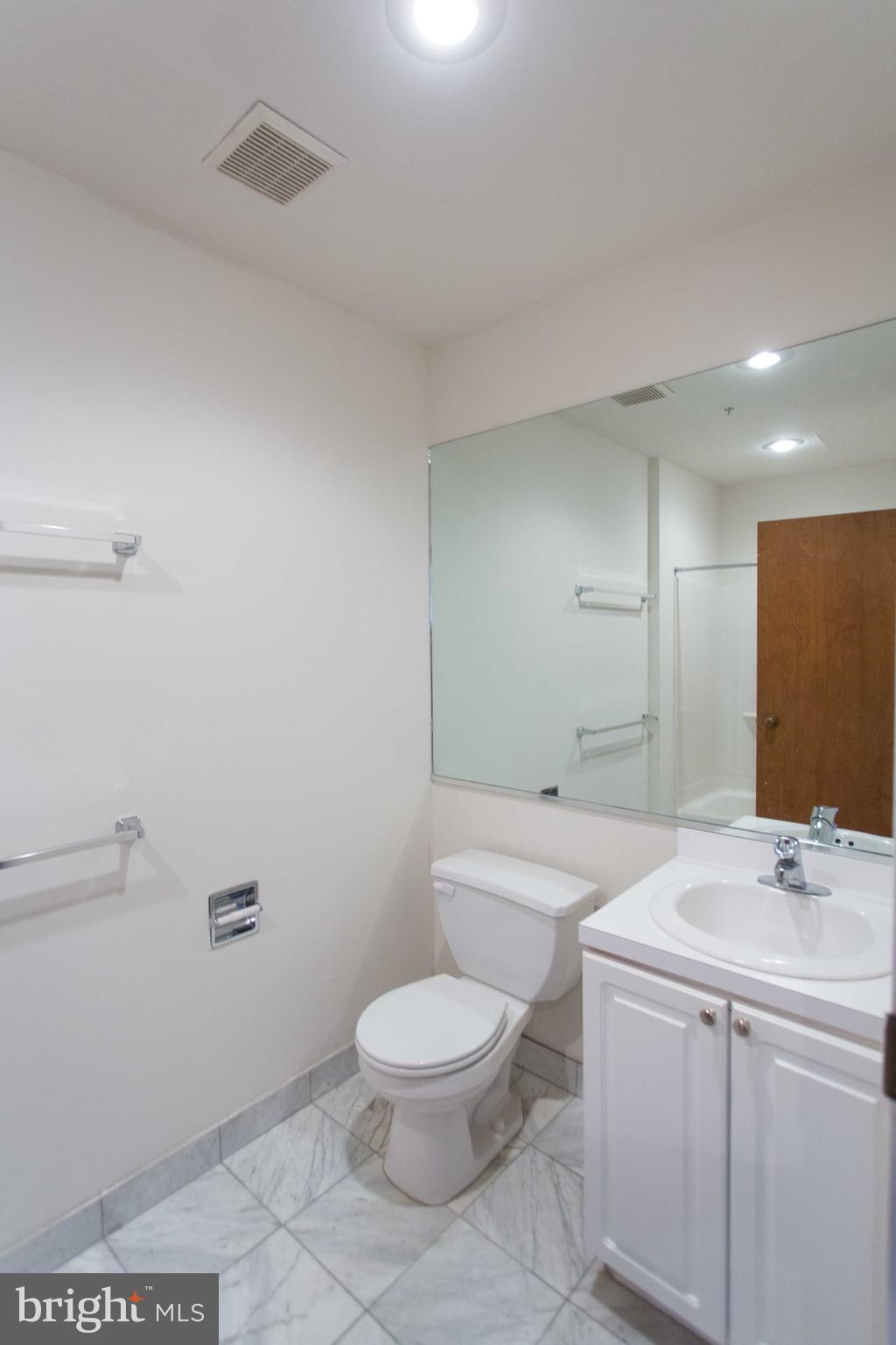 1411-5 Walnut Street, Unit 908 Philadelphia, PA 19102 - Photo 17 of 31 a bathroom with a granite countertop toilet a sink and a mirror
