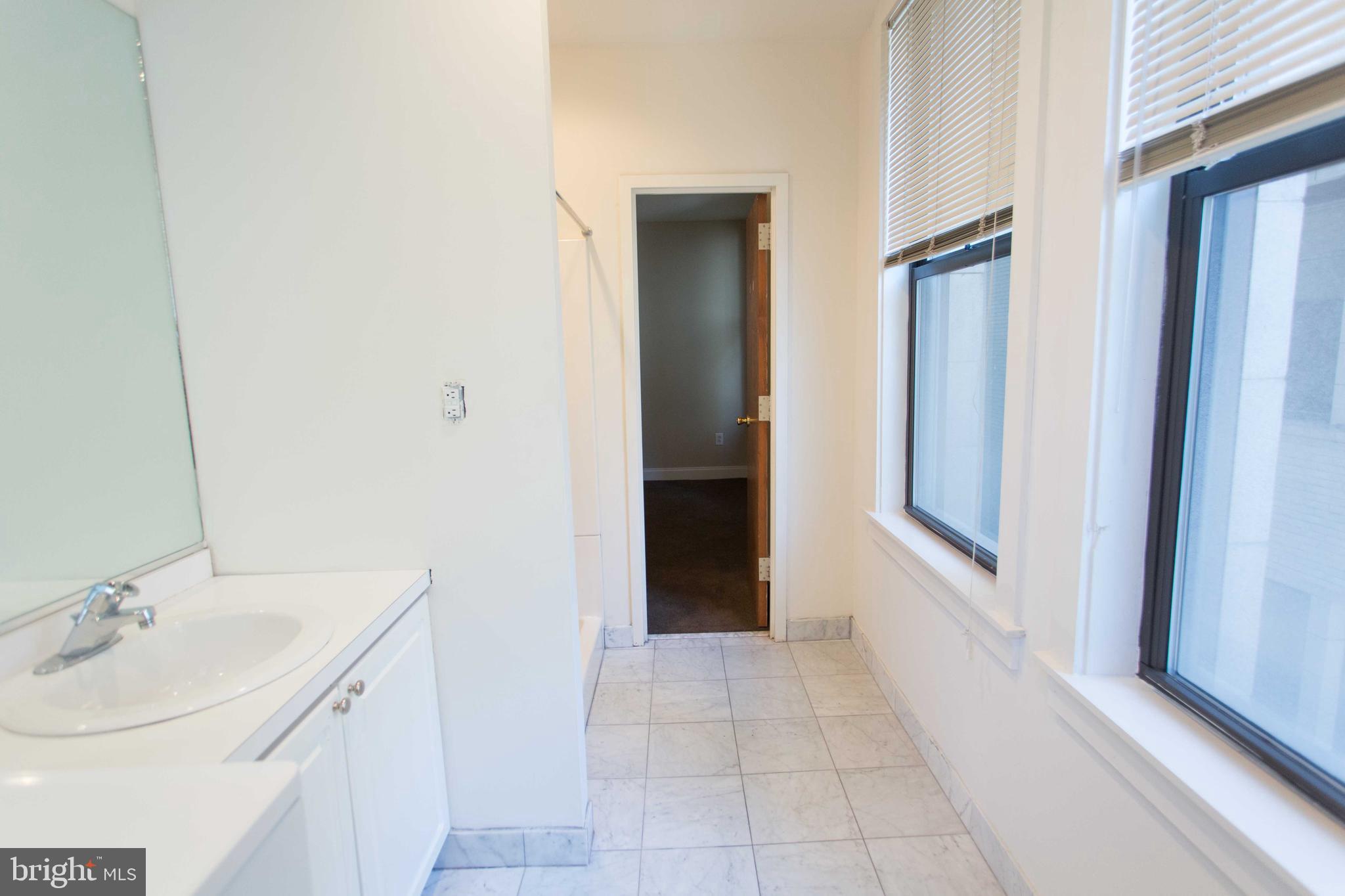 1411-5 Walnut Street, Unit 908 Philadelphia, PA 19102 - Photo 30 of 31 a bathroom with a sink and a mirror