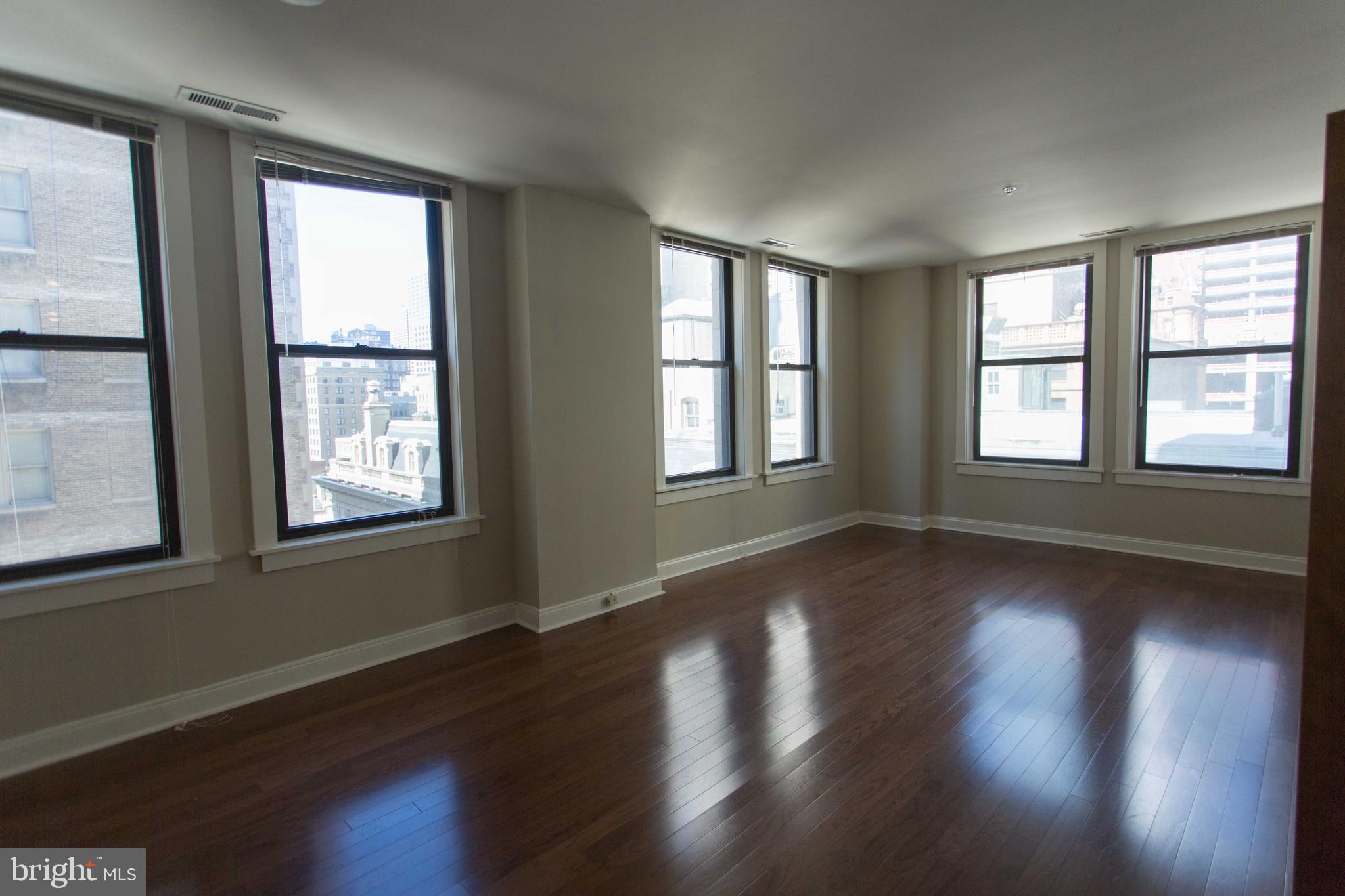 1411-5 Walnut Street, Unit 908 Philadelphia, PA 19102 - Photo 9 of 31 a view of an empty room with wooden floor and a window