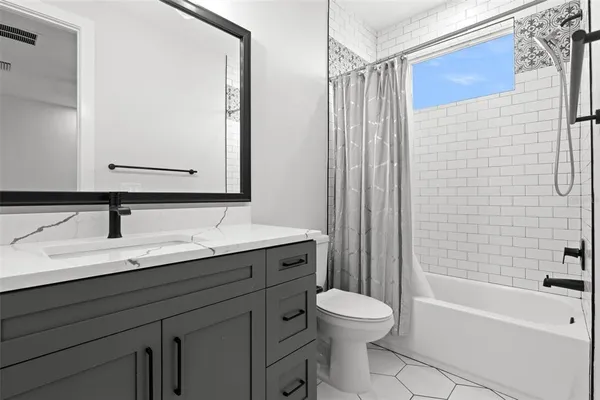 a bathroom with a granite countertop sink toilet a mirror and bathtub