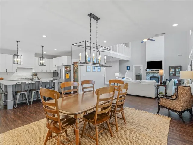 a kitchen with stainless steel appliances a dining table chairs and wooden floor