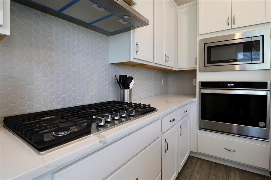 7955 Delwin Lane Reunion, FL 34747 - Photo 12 of 25 a kitchen with stainless steel appliances a stove a microwave and cabinets