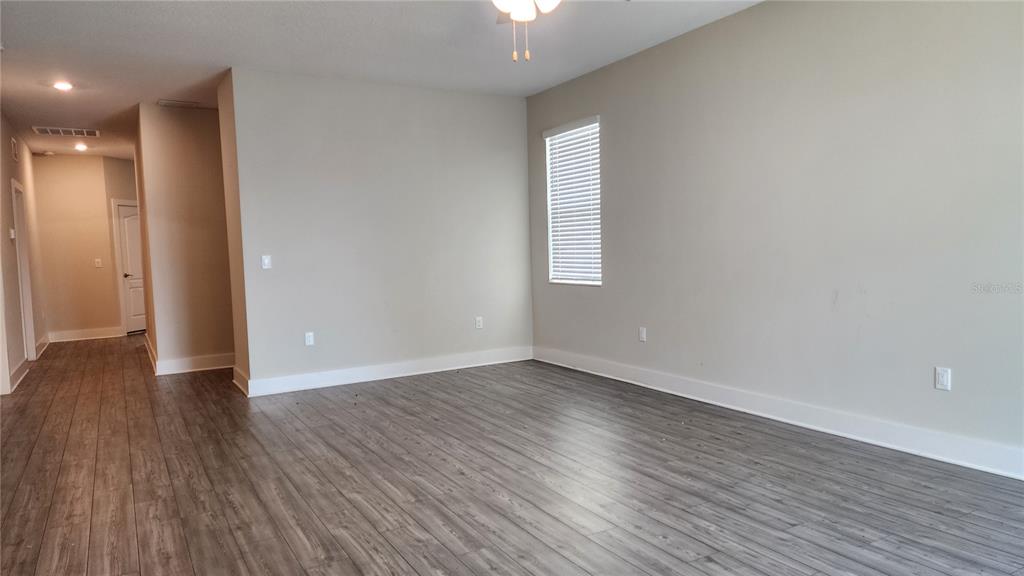 7955 Delwin Lane Reunion, FL 34747 - Photo 16 of 25 a view of an empty room with wooden floor and a window