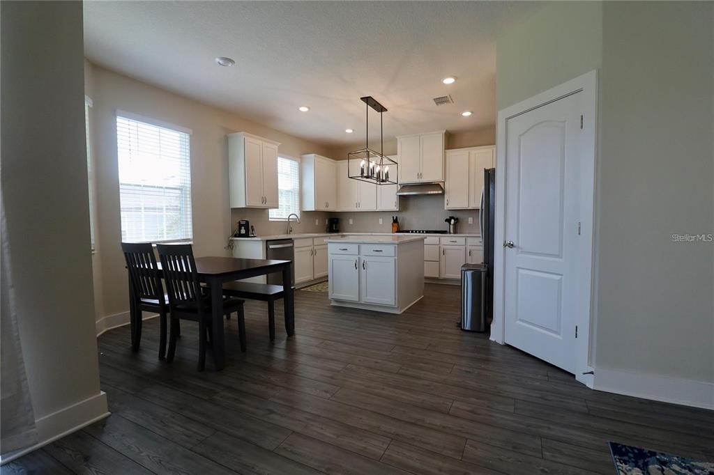 7955 Delwin Lane Reunion, FL 34747 - Photo 9 of 25 a kitchen with kitchen island granite countertop a sink cabinets and wooden floor