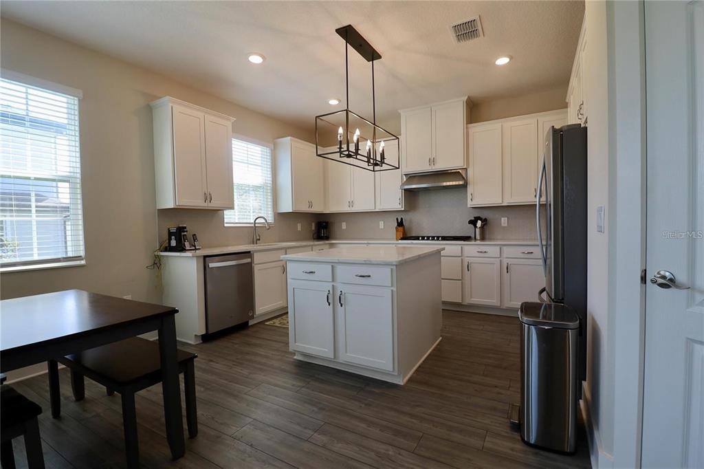 7955 Delwin Lane Reunion, FL 34747 - Photo 10 of 25 a kitchen with kitchen island granite countertop a sink a counter space appliances and cabinets