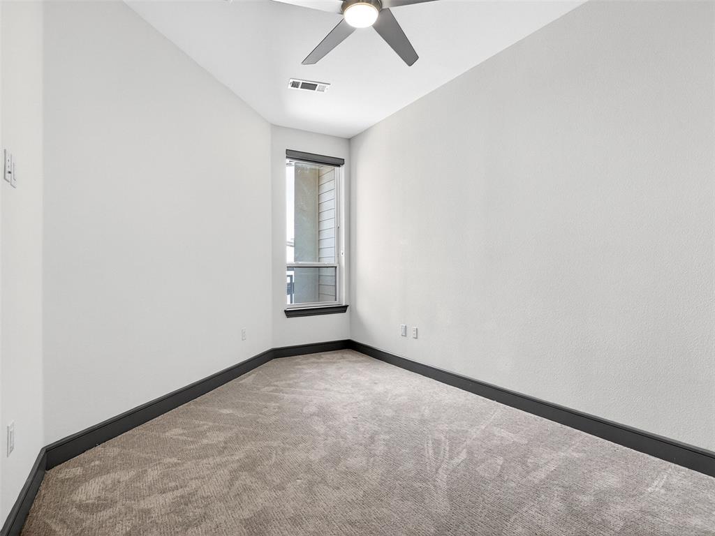 2700 Old Denton Road, Unit 3370 Carrollton, TX 75007 - Photo 15 of 35 an empty room with a chandelier fan and windows